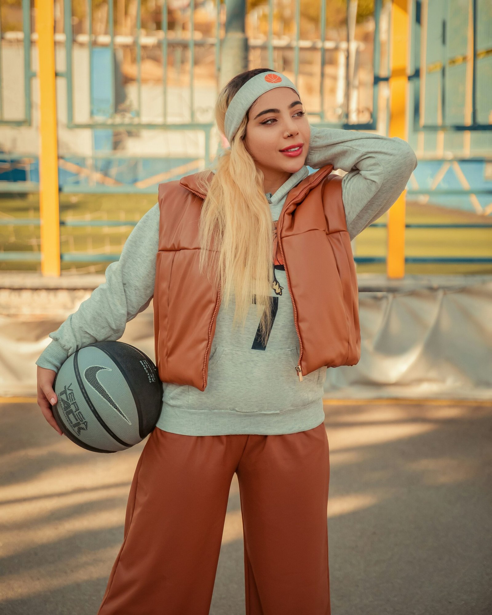 A woman holding a basketball while standing next to a basketball